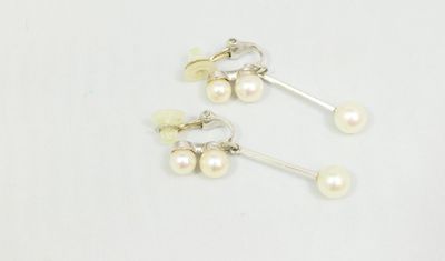 a pair of pearl earrings on a white background