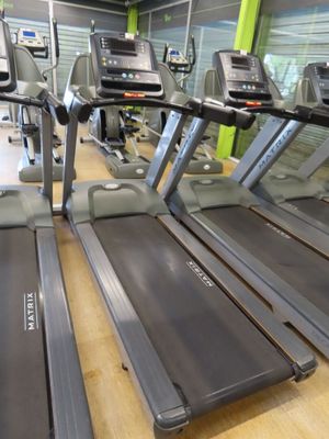 row of treads in a gym room with mirrors on the wall