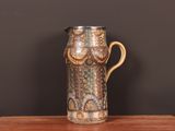a brown and blue vase sitting on a wooden table