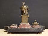 a statue of a man sitting on top of a table