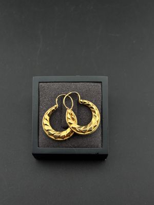 une paire de boucles d'oreilles créoles en or dans un coffret noir