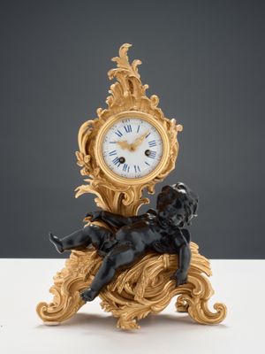 une petite horloge surmontée d'une statue