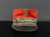 une image représentant un chapeau rouge posé sur une table noire