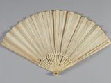 an ivory fan with a design on the side