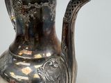a silver tea pot that is sitting on a table