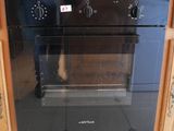 un four noir logé à l'intérieur d'un meuble en bois