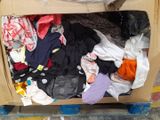 a cardboard box filled with clothes on the floor