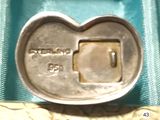 a silver heart shaped metal object on a blue cloth