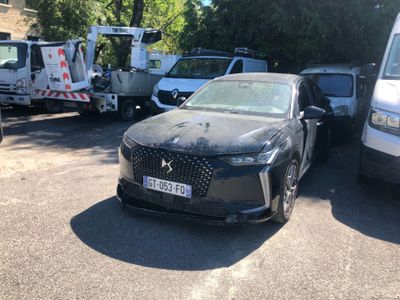 une voiture noire garée sur un parking à côté d'un camion blanc