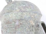 a close up of a metal helmet on a white surface