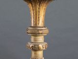 a gold candle holder with a candle on top of it