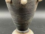 an image of a vase on a pedestal on a table