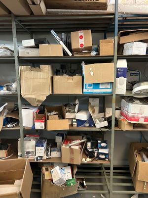 boxes and other items are stacked on a shelf in a room
