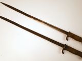 une paire de deux vieilles épées en bois posées sur un fond blanc