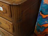 a picture of a painting and a dresser in a room