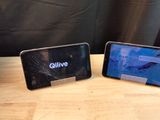 two cell phones sitting on a table with a broken screen