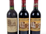 three bottles of wine sitting next to each other on a white surface