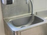 a stainless steel sink with a soap dispenser attached to it
