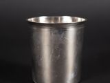 un gros plan d'une tasse en métal posée sur une surface noire