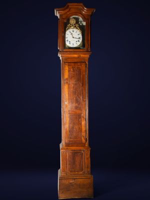 une grande horloge de parquet en bois sur un fond bleu foncé