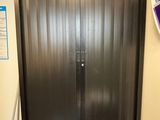 une porte en métal noir dans un coin d'une pièce