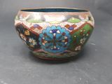 a colorful bowl sitting on a table with a gray background