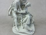 une statue représentant un homme tenant un enfant sur ses genoux