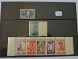 plusieurs timbres différents sur un dossier noir, avec une personne tenant l'un d'entre eux