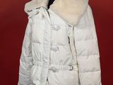 une veste blanche à col de fourrure sur un mannequin
