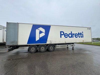 a white semi truck with a blue and white logo parked in a parking lot