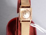 a gold watch sitting in a red box on a table