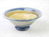 a small blue and yellow bowl on a white surface