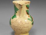 un petit vase orné d'une inscription, posé sur une table