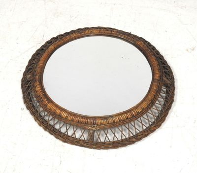 an image of a round wicker mirror on a white surface