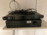 two black electronic devices sitting on top of each other on a shelf