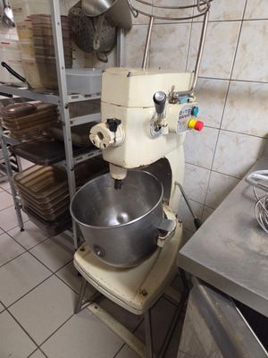 un mixeur dans une cuisine où le plan de travail est encombré de nombreuses casseroles et poêles