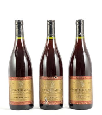 trois bouteilles de vin posées les unes à côté des autres sur une surface blanche