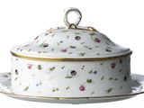 a white plate with a flowered covered dish on it