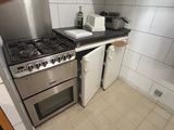 une cuisine équipée d'une cuisinière, d'un micro-ondes et d'un réfrigérateur