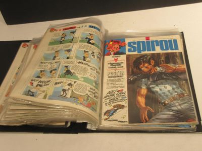 un livre ouvert posé sur une table sur laquelle se trouvent des bandes dessinées