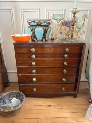 une commode sur laquelle est posé un bol, à côté d'un lit