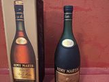 une bouteille de cognac à côté d'un carton de vin