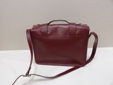 a red leather handbag sitting on top of a white table
