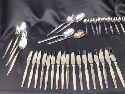 a lot of spoons and forks laid out on a table