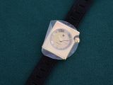 a watch with a face on it on a green surface
