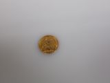a close up of a gold coin on a white surface