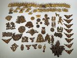 many different types of gold jewelry on a white surface
