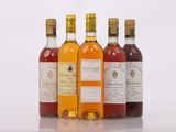 four bottles of wine are lined up in a row on a white surface