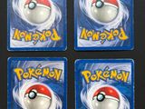a close up of four pokemon magnets on a black surface