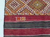 a close up of a red, black, and white rug